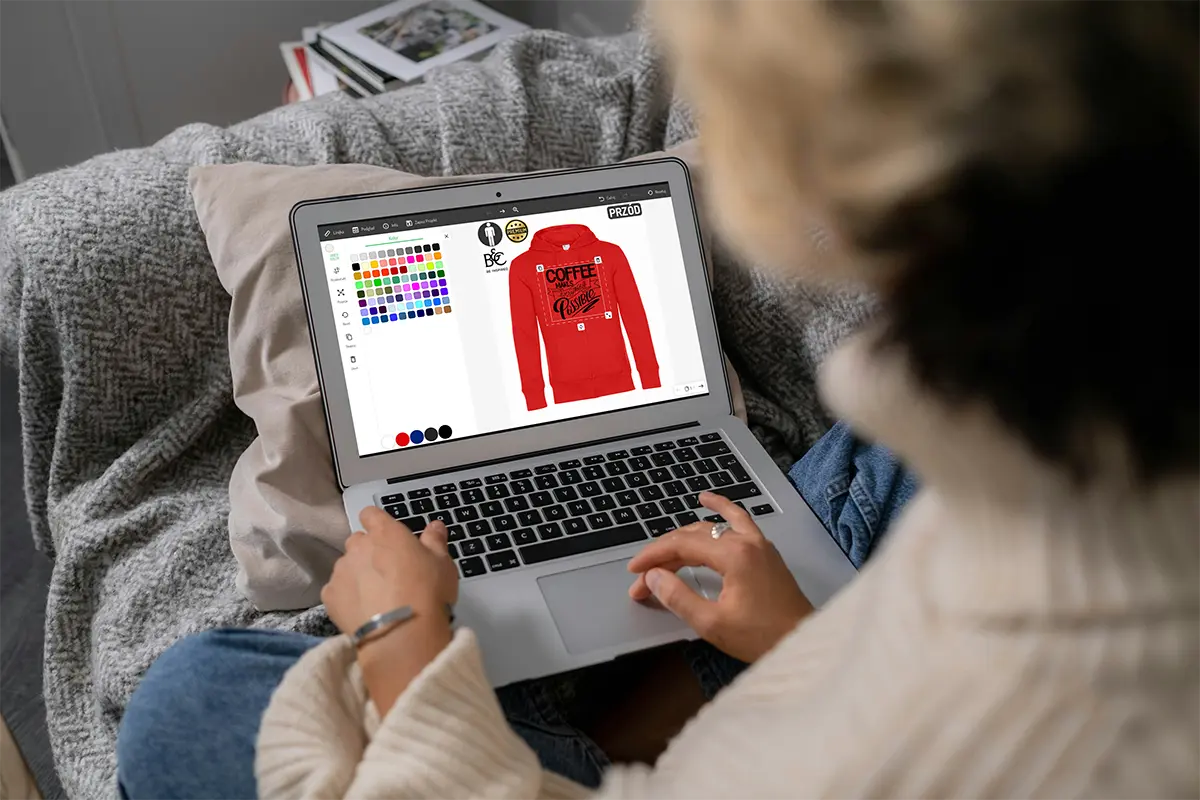 kreator nadruków na bluzach uruchomiony na laptopie, projektowanie czerwonej rozpinanej bluzy